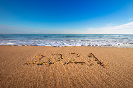 Happy New Year 2021 concept, lettering on the beach. Written text on the sea beach at sunrise.の写真素材