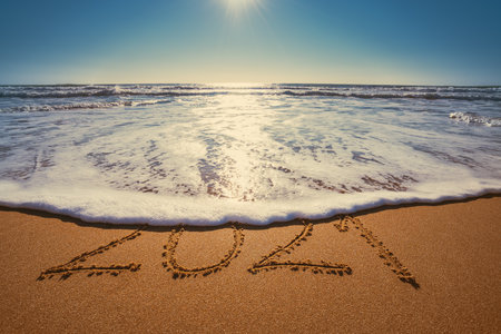 Happy New Year 2021 concept, lettering on the beach. Written text on the sea beach at sunrise.の写真素材