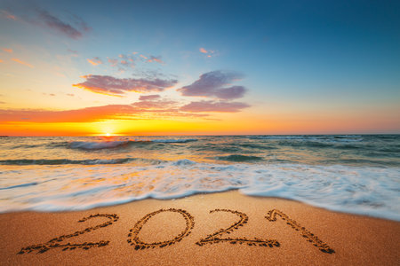 Happy New Year 2021 concept, lettering on the beach. Written text on the sea beach at sunrise.の写真素材