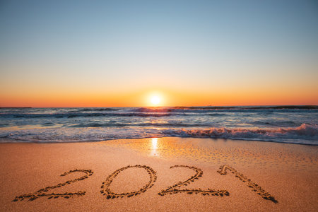 Happy New Year 2021 concept, lettering on the beach. Written text on the sea beach at sunrise.の写真素材