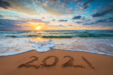 Happy New Year 2021 concept, lettering on the beach. Written text on the sea beach at sunrise.の写真素材