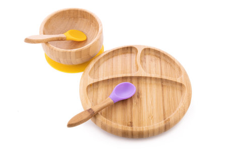 Wooden bowl. Bamboo plate with spoon isolated on white backgroundの写真素材