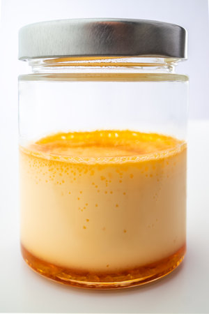 Cream caramel in a jar isolated on white background