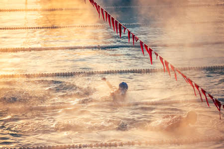 Corridor Lanes and swimmer in swimming pool with fog over the water. Sport Competition.の写真素材