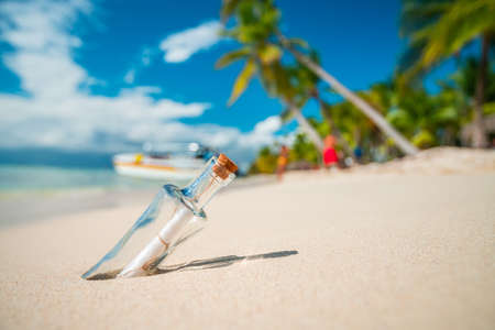 Bottle with a message on a tropical island beach.の写真素材