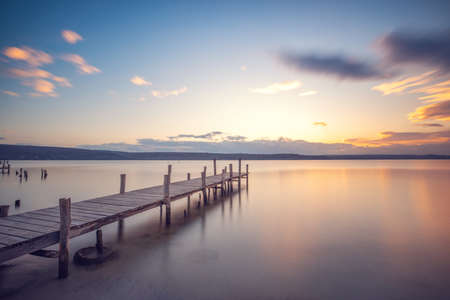 Old wooden dock at the lake, sunset shotの写真素材