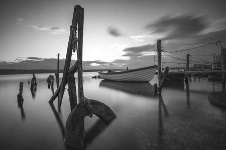Small dock and fishing boat at fishing village, black and white long exposureの写真素材