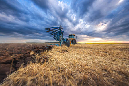Tractor plowing the fields , agricultural landscapeの写真素材