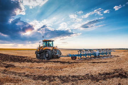 Tractor plowing the fields , agricultural landscapeの素材 [FY310165392907]