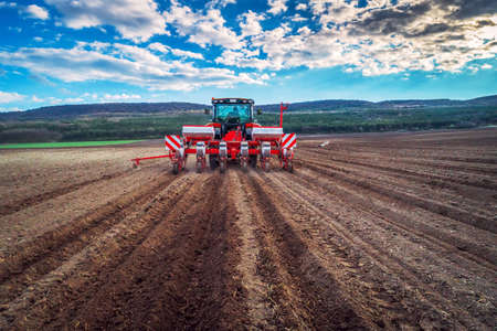 Farmer in tractor preparing farmland with seedbedの写真素材