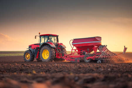 Farmer in tractor preparing farmland with seedbed for the next yearの写真素材