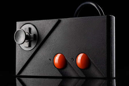 Retro joystick from 8-bit consoles. Game controller isolated on black background