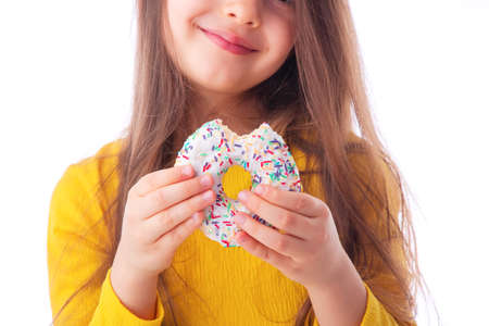 Sweet little girl eating white donutの写真素材