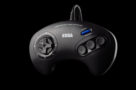Varna, Bulgaria, 30 Mart 2021:- A retro Sega Mega Drive 16-bit gaming console's controller isolated on a white background Retro joystick from 8-bit consoles. Game controller isolated on black backgroundのeditorial素材