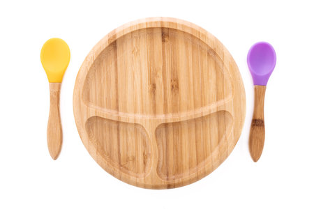Wooden bowl. Bamboo plate with spoon isolated on white backgroundの写真素材