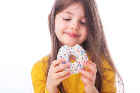 Sweet little girl eating white donutの写真素材