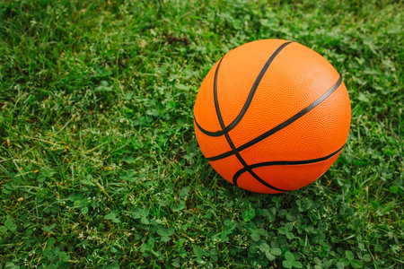 Basketball ball on a fresh green grass. Outdoor kids playground.の写真素材