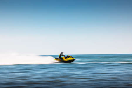 Varna, Bulgaria - 13. 06 2021: summer fun by the sea, girl ride a jet ski in spray of waterの写真素材