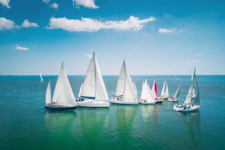 Regatta sailing ship yachts with white sails at opened sea. Aerial view of sailboat in windy condition.のeditorial素材