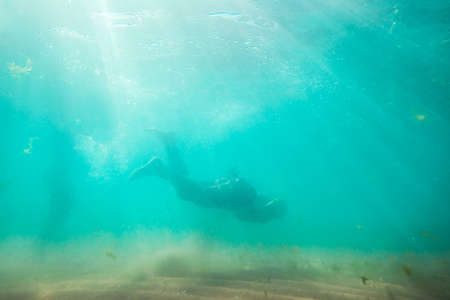 Young man, swimming underwaterの写真素材