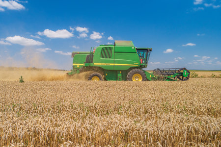 Varna Region, Bulgaria - July 15, 2021: A modern John Deere W650 Combine Harvester on a yellow fieldのeditorial素材