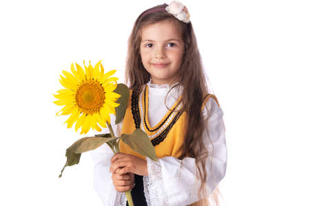 Girl in traditional Bulgarian folklore costume and sunflower. Kid portrait.の写真素材