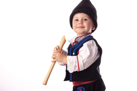 Baby boy in traditional Bulgarian folklore costumes. Happy kid posing with flute, wooden whistle.の写真素材