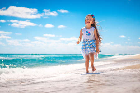 Happy girl running on tropical beach on summer holidays.の写真素材