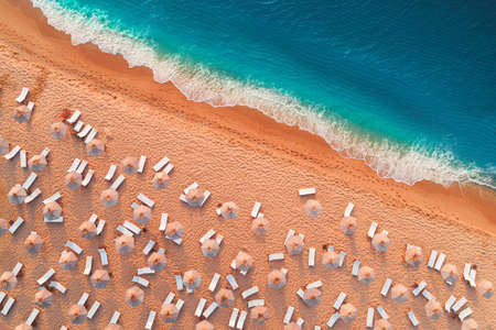 Aerial top view from drone of sandy beach with turquoise sea waves with copy space for text.の写真素材