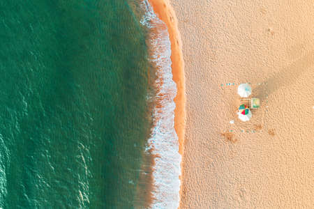 Aerial top view on the beach. Umbrellas, sand and sea wavesの写真素材