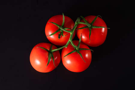 Fresh organic tomatoes on black background. Ripe red tomato.の写真素材