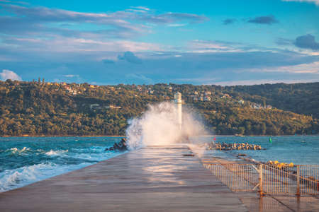 Lighthouse and splashing wave in Varna, Bulgariaの写真素材