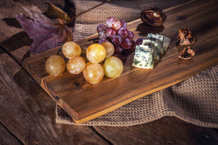 Top view of grape and cheese on wooden tableの写真素材
