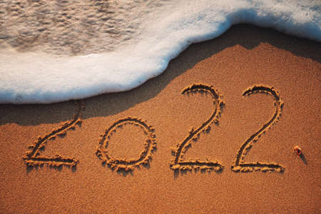 Happy New Year 2022 concept, lettering on the beach. Sea sunrise.の写真素材