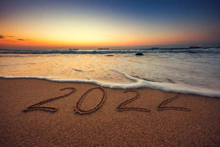 Happy New Year 2022 concept, lettering on the beach. Sea sunrise.の写真素材
