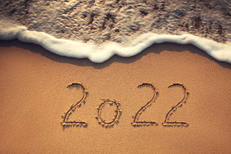 Happy New Year 2022 concept, lettering on the beach. Sea sunrise.の写真素材