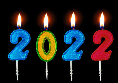 2022 Happy new year burning party candles isolated on black.の写真素材