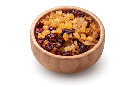 Organic dried raisins and cranberries in wooden bowl isolated on white background.の写真素材
