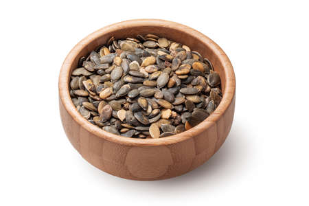Pumpkin seeds in wooden bowl isolated on white background. Organic superfood.の写真素材