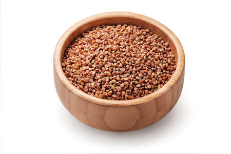 Buckwheat grains, seeds in wooden bowl isolated on white background.の写真素材