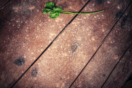 Vintage wooden table with flour and fresh herbs as food backgroundの写真素材