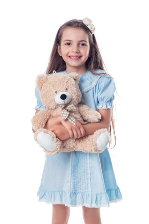Happy beautiful girl with his favorite toy fluffy friend teddy bear. Childhood and toys.の写真素材