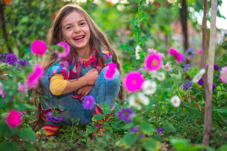 Happy girl farmer woman  in colourful blooming flowers in a flower gardenの写真素材
