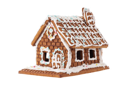 Christmas Gingerbread house in snow decorated with glaze, isolated on whiteの写真素材
