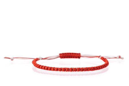 Martisor talisman, martenitsa, martenitza for 1 March Baba Marta isolated on white background. Traditional accessory for holiday of early spring in Bulgaria, Romania, Moldova. Red and White yarn strings.の写真素材