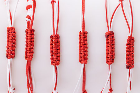 Martisor talisman, martenitsa, martenitza for 1 March Baba Marta isolated on white background. Traditional accessory for holiday of early spring in Bulgaria, Romania, Moldova. Red and White yarn strings.の写真素材