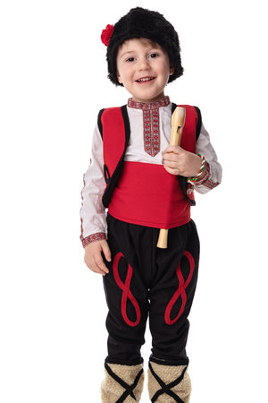 Bulgarian boy in traditional folklore costumes with spring flowers snowdrop and handcraft wool bracelet martenitsa symbol of Baba Martaの写真素材