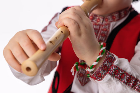 Bulgarian boy in traditional folklore costumes with spring flowers snowdrop and handcraft wool bracelet martenitsa symbol of Baba Martaの写真素材