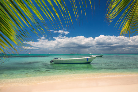 Beautiful carribean sea and boat on the shore, panoramic view from the beachの写真素材