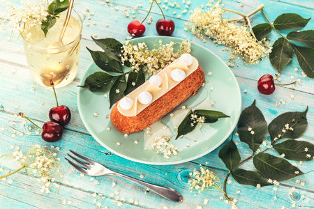 French eclair grazed with chocolate or sweet Italian profiteroles with fresh cold dwarf-elder juice, sweet tasty, food fresh summer background.の写真素材